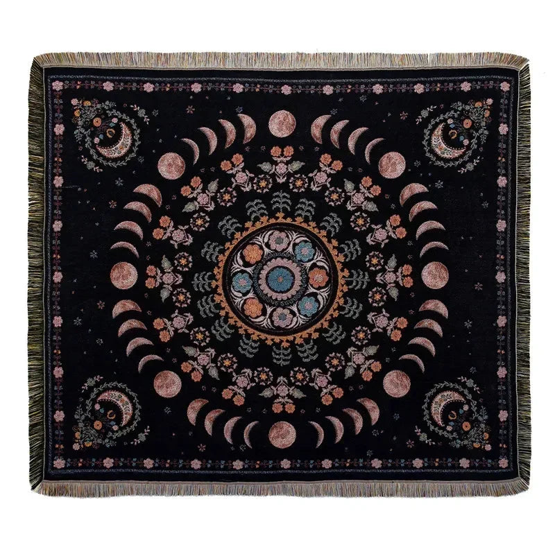 A dark black woven throw blanket featuring a circular mandala design in shades of pink, orange, and teal.