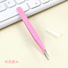 A pink precision craft tool with a straight tip is placed on a light surface next to a white object and a keyboard.