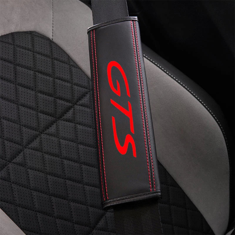 Black leather seat belt cover with red stitching and GTS logo on a car seat.