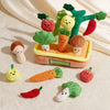 A set of felt vegetable toys including a carrot, tomato, and mushroom, arranged on a white surface.