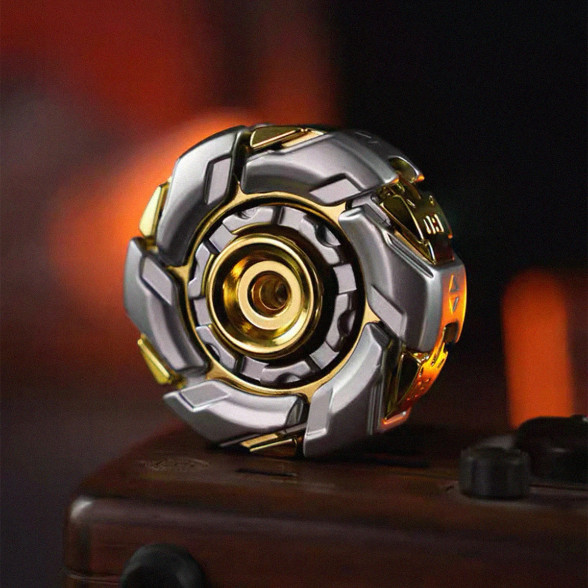 A close-up of a silver and gold fidget spinner with intricate geometric design resting on a dark surface.