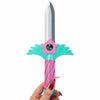 A pink and teal dagger key necklace with a green gemstone and a silver blade, held by a hand.