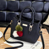 Black vintage PU leather shoulder bag with gold hardware and a fluffy red and white tassel detail.