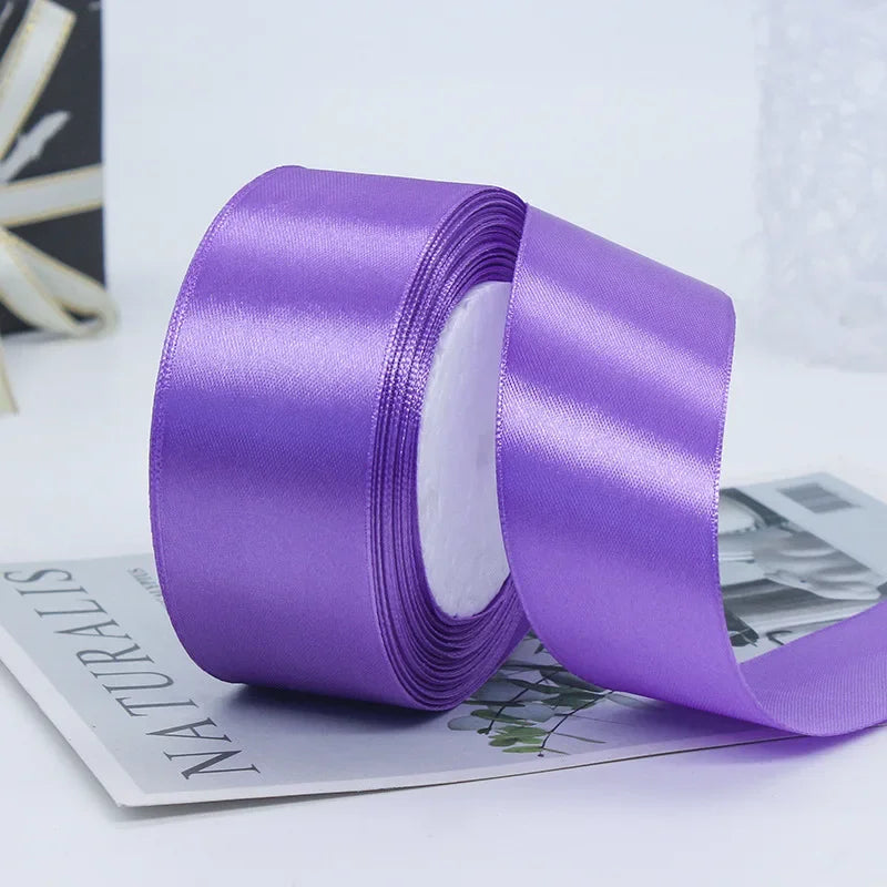 A roll of vibrant purple satin ribbon used for gift wrapping or DIY crafts.