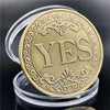 A round gold commemorative token with the word YES embossed on its surface.
