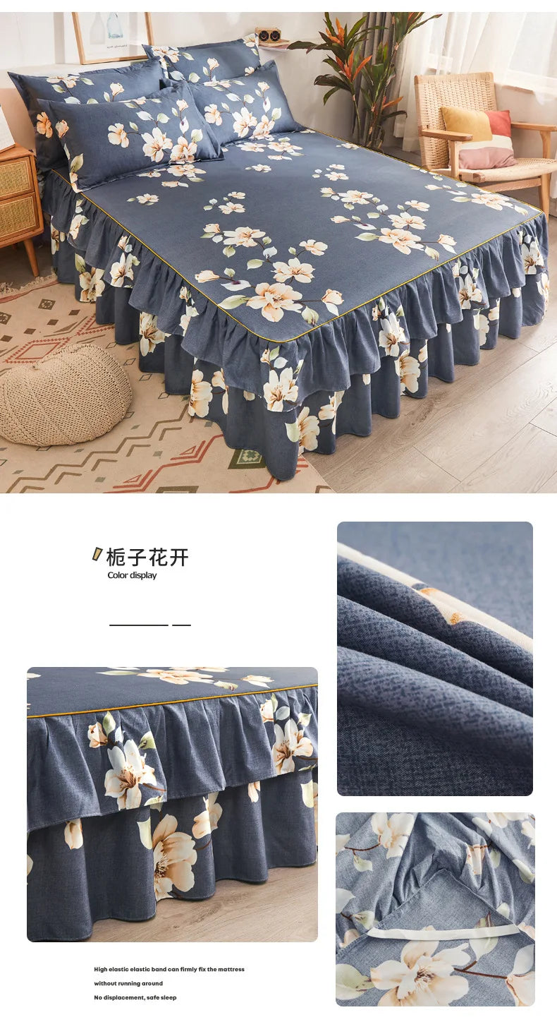 Un jupon de lit bleu marine imprimé avec des motifs floraux blancs et jaunes sur un lit.
