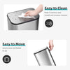 A stainless steel trash can with a soft-close lid being wiped clean, demonstrating its easy to clean feature.