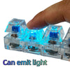A hand holds several clear plastic LED mechanical keychain fidget toys that emit blue light.