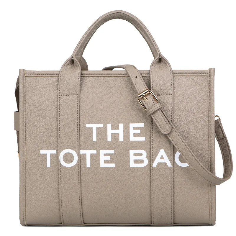 حقيبة يد جلدية فاخرة بيج من PU تحمل عبارة "THE TOTE BAG" على الواجهة.