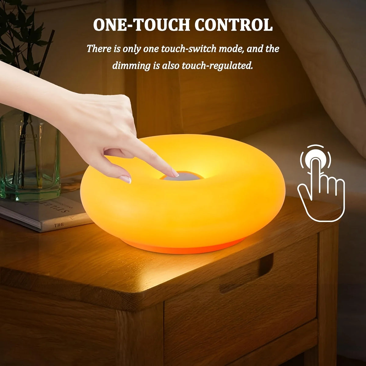 A hand touches a round, orange LED light fixture on a wooden cabinet surface.