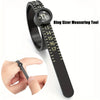 A black ring sizing tool with a magnifying lens and adjustable ruler is shown next to a hand for measuring rings.
