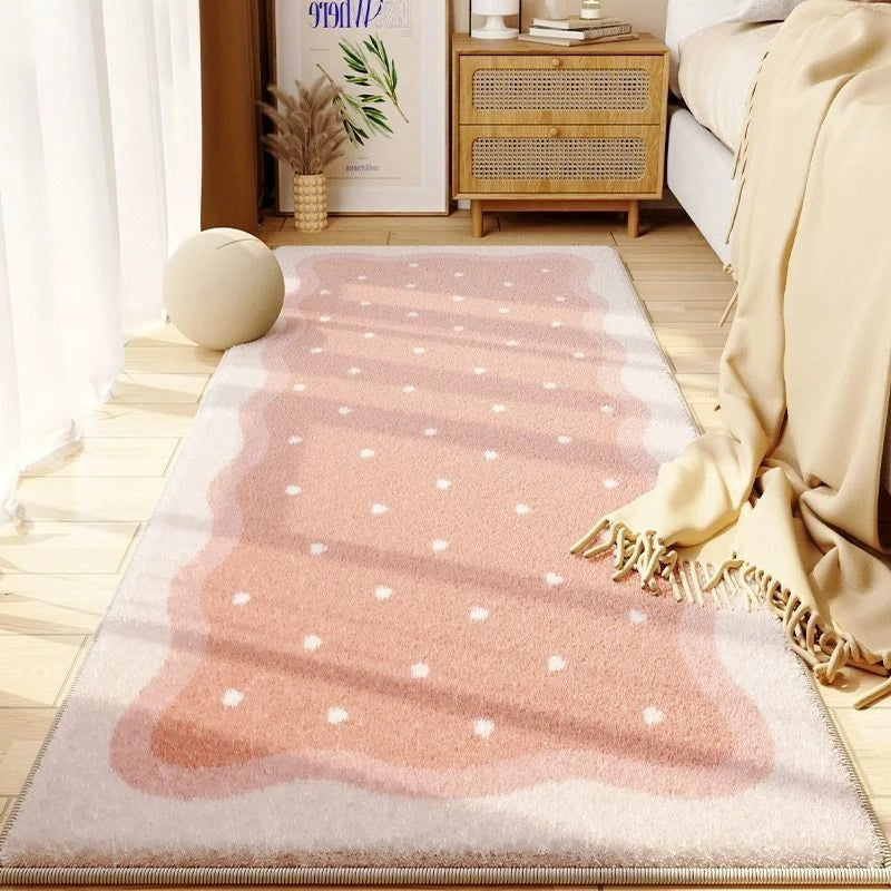A plush, light pink and beige decorative area rug with a subtle pattern placed on a wooden floor.