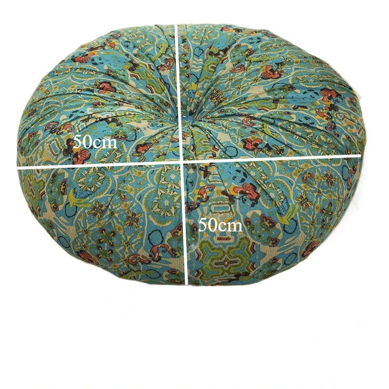 A round, teal and gold bohemian cotton linen floor cushion with a white cross marking its dimensions.