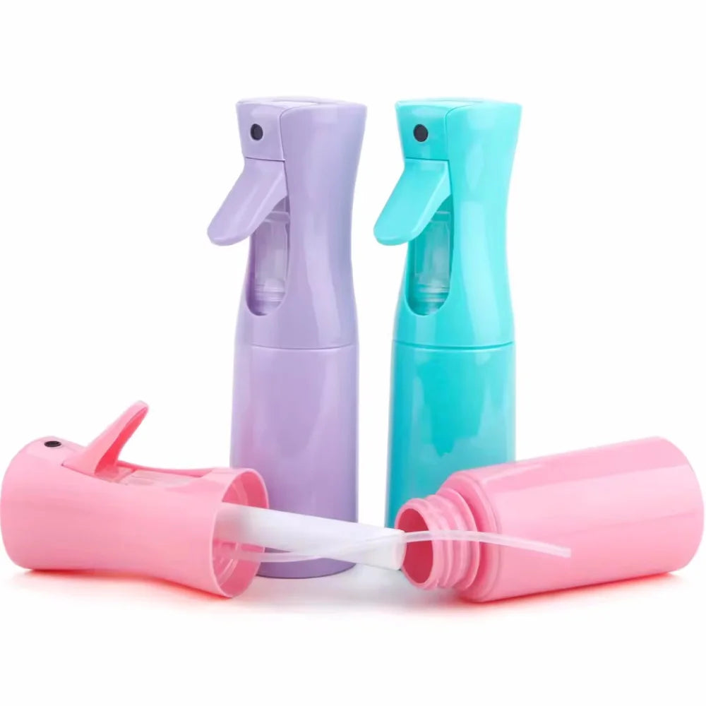 Three colorful refillable mist spray bottles in purple, teal, and pink for hair, skin, or home use