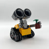 Set de bloques de construcción mini robot amarillo y gris con ojos grandes y antena verde.