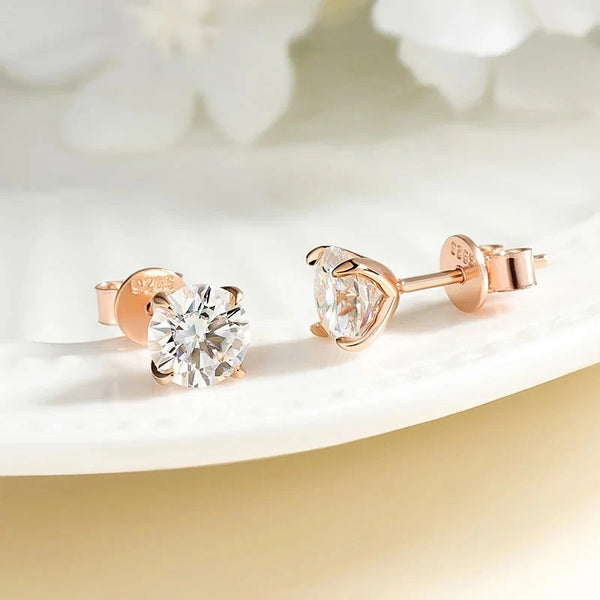 Un par de pendientes de diamantes de moissanita transparente en plata esterlina y sujetadores bañados en oro rosado.