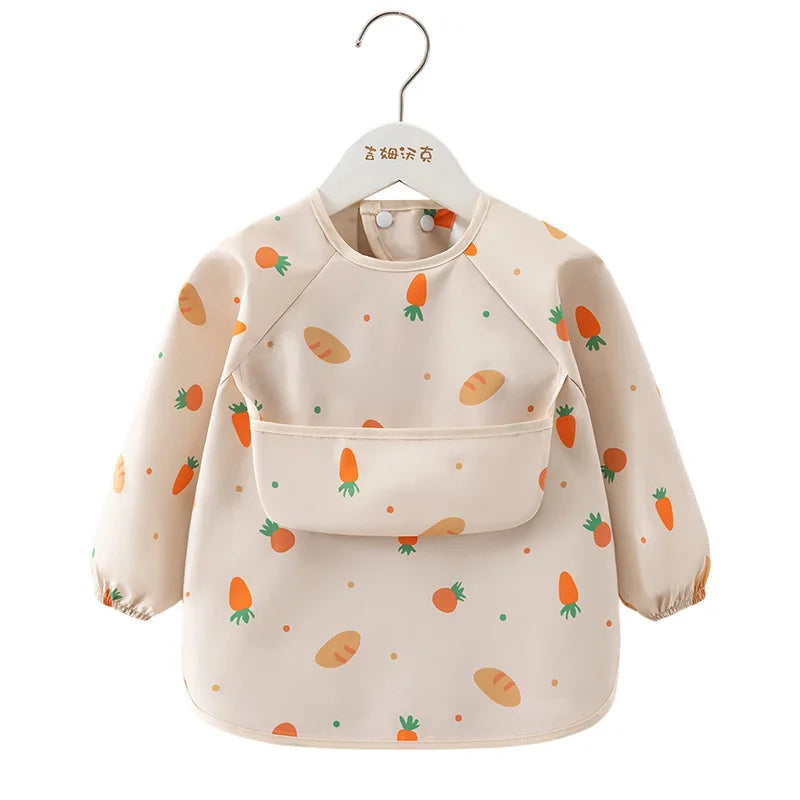 A beige children's waterproof long sleeve feeding bib with a catch pocket decorated with small fruit illustrations.