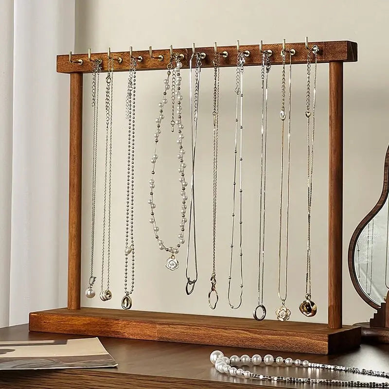 Porte-clés en bois pour bijoux, présentant des colliers et chaînes en argent et or.