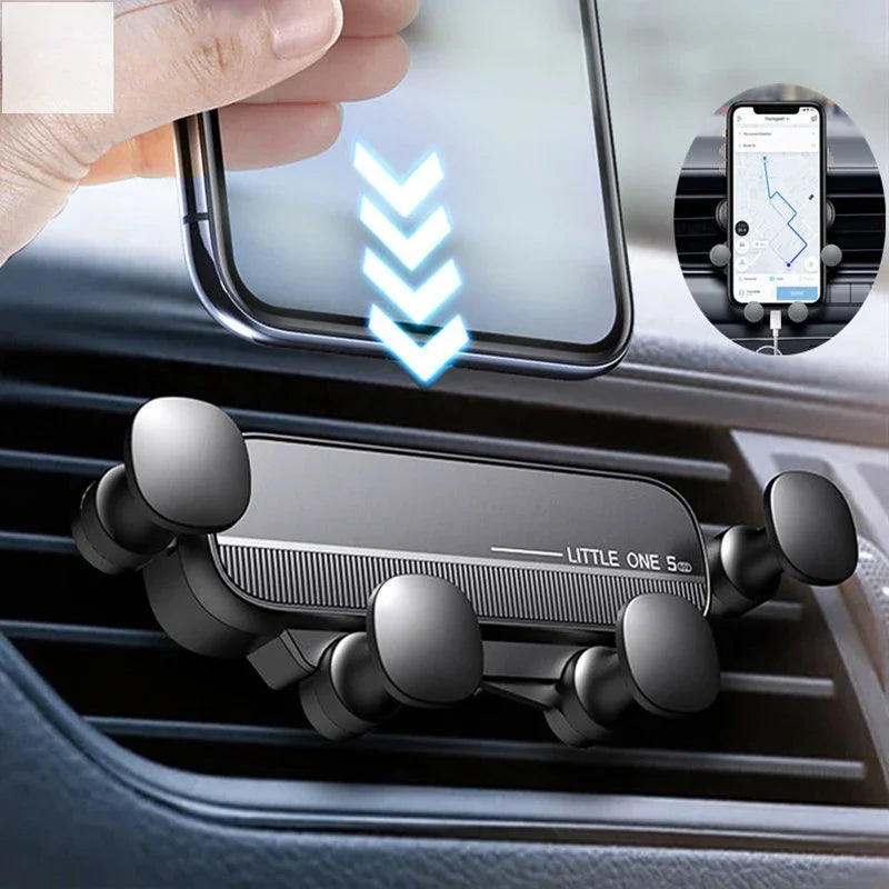 A black gravity phone mount is installed in a car air vent, with a smartphone displaying navigation on a nearby screen.