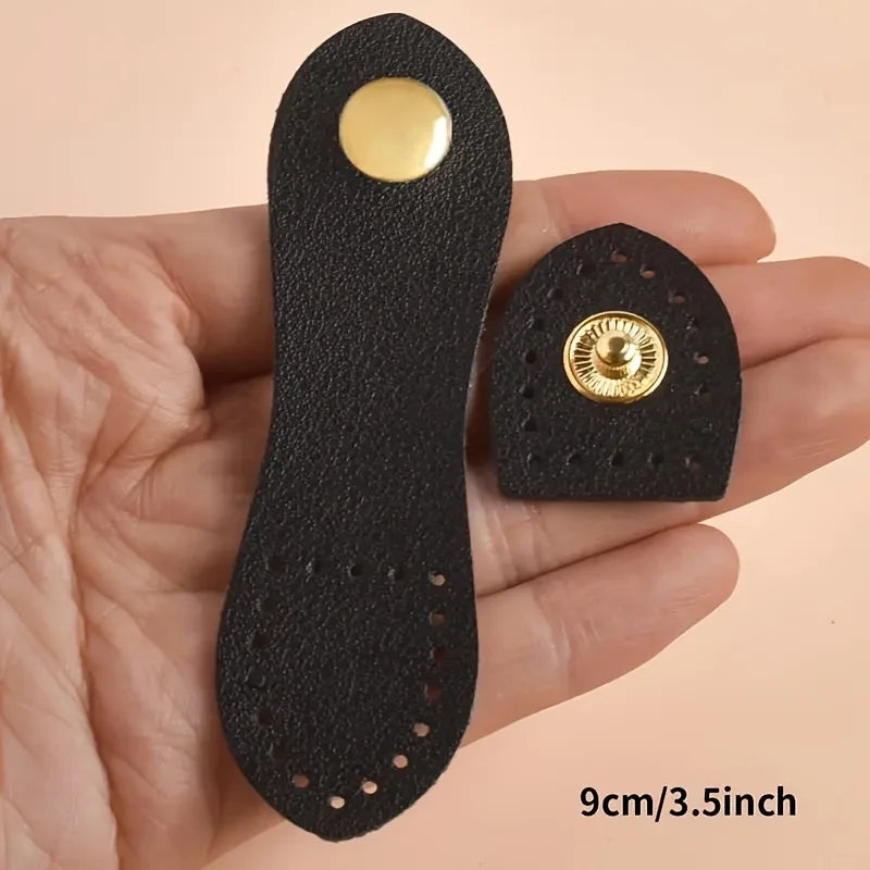 A black leather buckle clasp with a gold accent is shown in a person's hand.