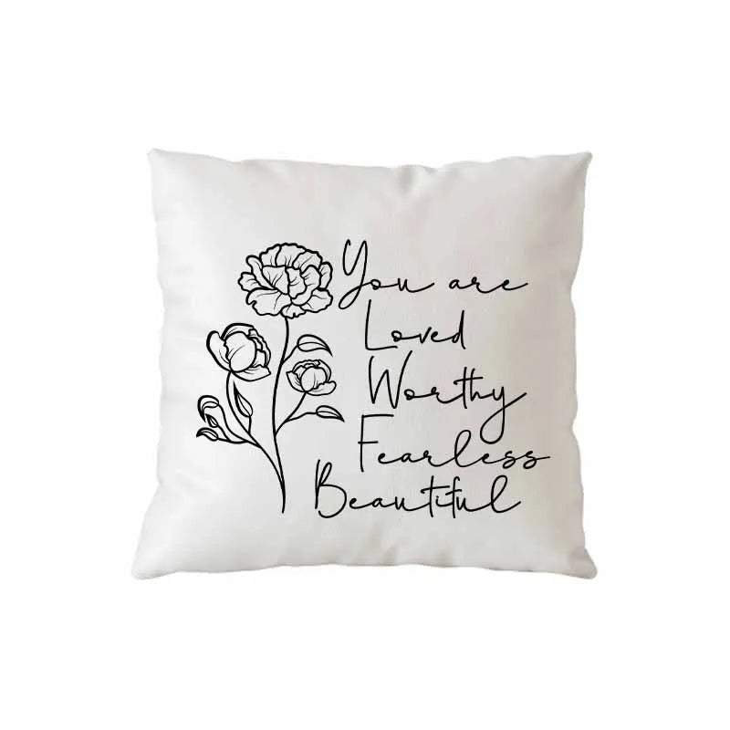 A white throw pillow with black script text that reads You are loved worthy fearless beautiful