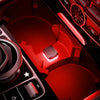 A close-up view of a red car interior featuring an ambient light switch and controls.