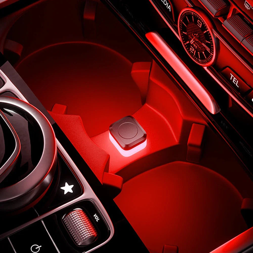 A close-up view of a red car interior featuring an ambient light switch and controls.