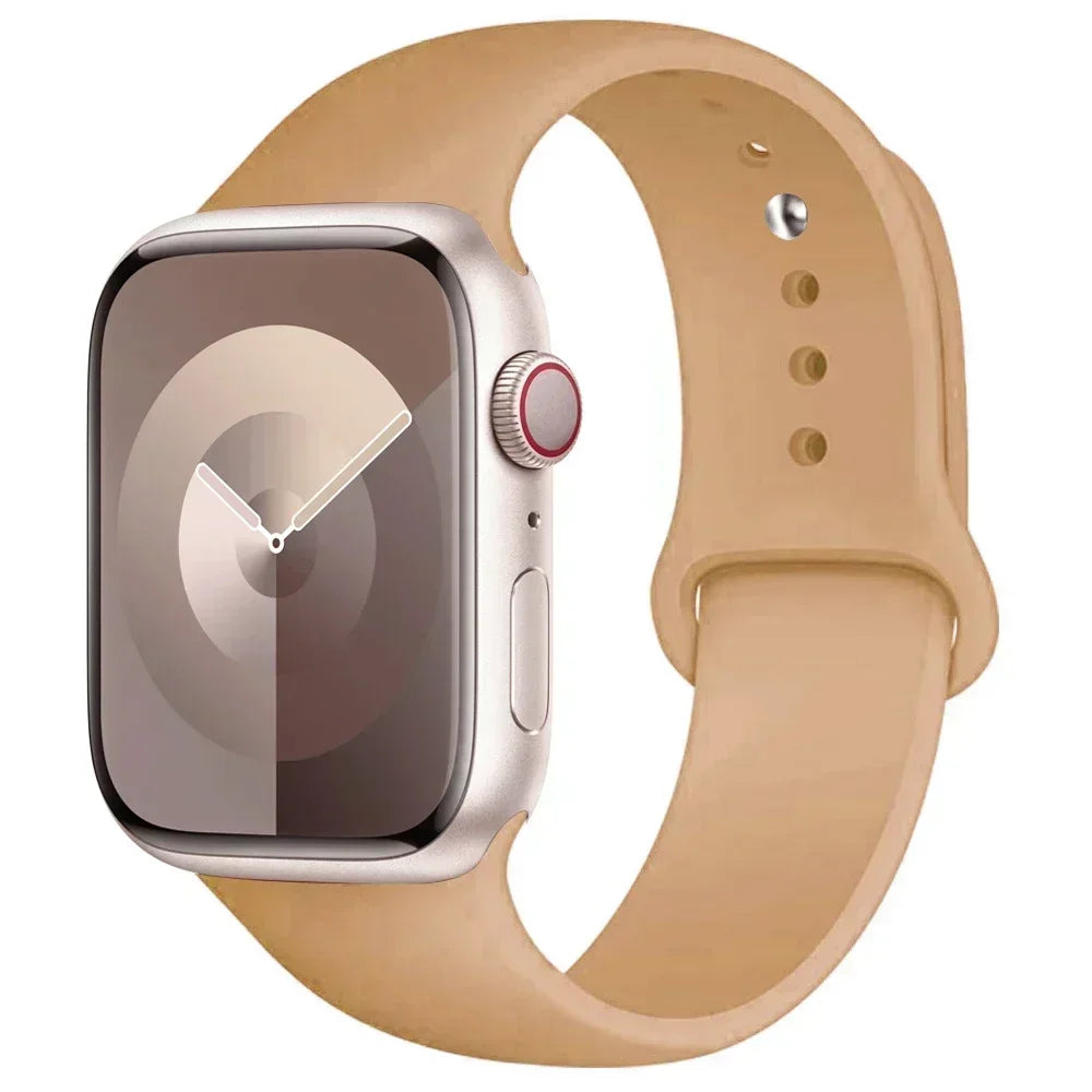 A silver Apple Watch is shown with a tan silicone sport band on a white background.