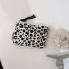 A small leopard print cosmetic bag with a black drawstring is displayed on a white surface.