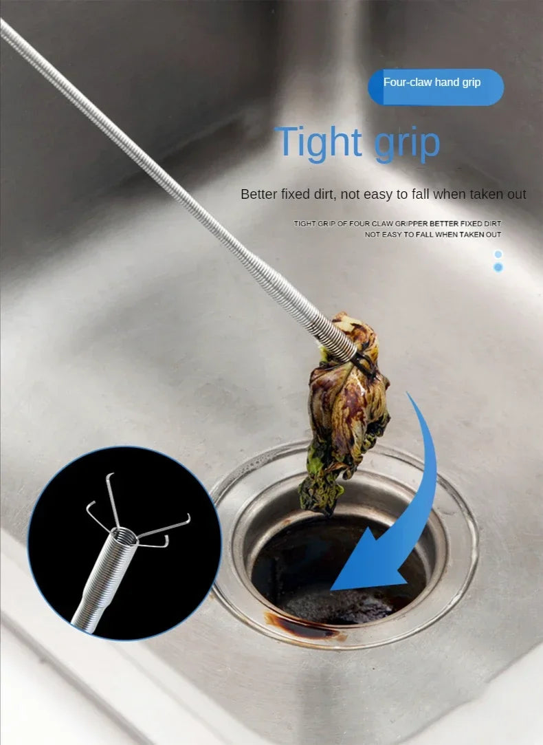 A close-up of a four-claw hand grip drain tool being used to remove a stuck item from a kitchen sink drain.