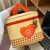 A yellow insulated lunch bag with an orange handle and a red heart design featuring a cartoon character.