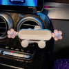 A white gravity car phone mount is shown installed in a car air vent.