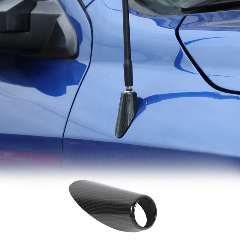 Close-up of a black carbon fiber antenna base cover installed on a blue Dodge RAM 1500 vehicle.