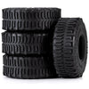 A stack of four black mud terrain rubber tires for RC crawlers.
