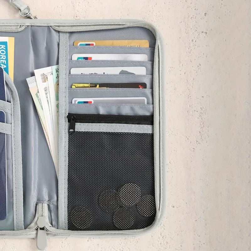 Porta-pasaportes gris con bloqueo RFID y correa de muñeca, mostrado contra un fondo claro.