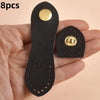 Eight black leather buckle clasps with gold accents shown in a hand