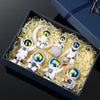 A set of handcrafted astronaut figurine resin spacemen displayed in a dark blue box with straw-like padding.