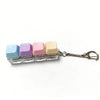A set of five colorful mini mechanical keyboard fidget keychains in pastel shades attached to a silver chain.