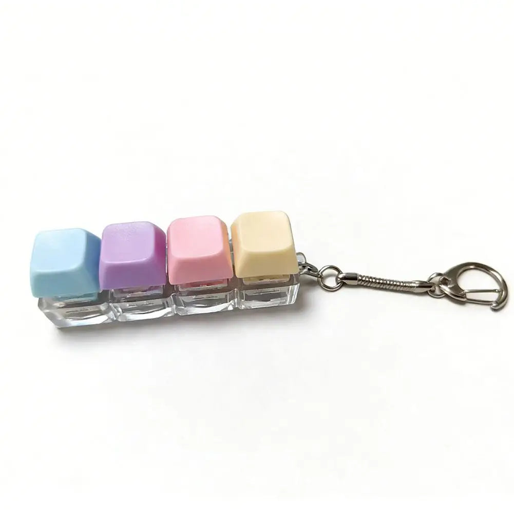 A set of five colorful mini mechanical keyboard fidget keychains in pastel shades attached to a silver chain.