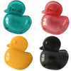 A set of four silicone toothbrush head covers in teal, pink, yellow, and black.