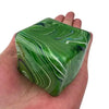 Une main tient un cube de jeu en gel apaisant marbré vert et blanc.