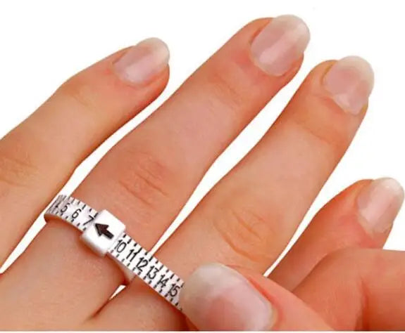 A hand is wearing an adjustable ring and bracelet sizer measuring tool on its finger.
