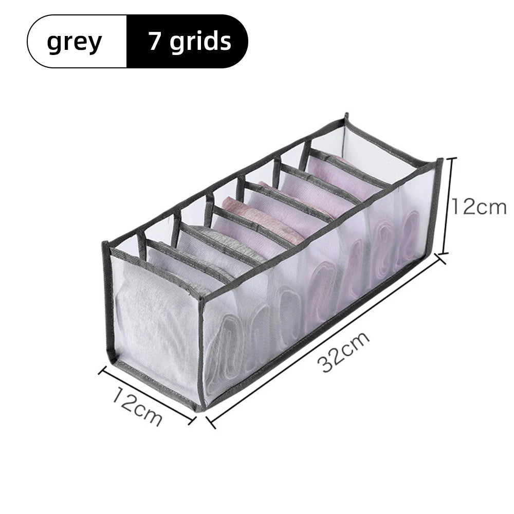 A grey foldable fabric closet organizer with seven grids and handles, shown from above.