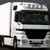 Ein weißer LKW mit blinkenden Solaranwarnleuchten auf der Dach- und Kühlergrillmontage.
