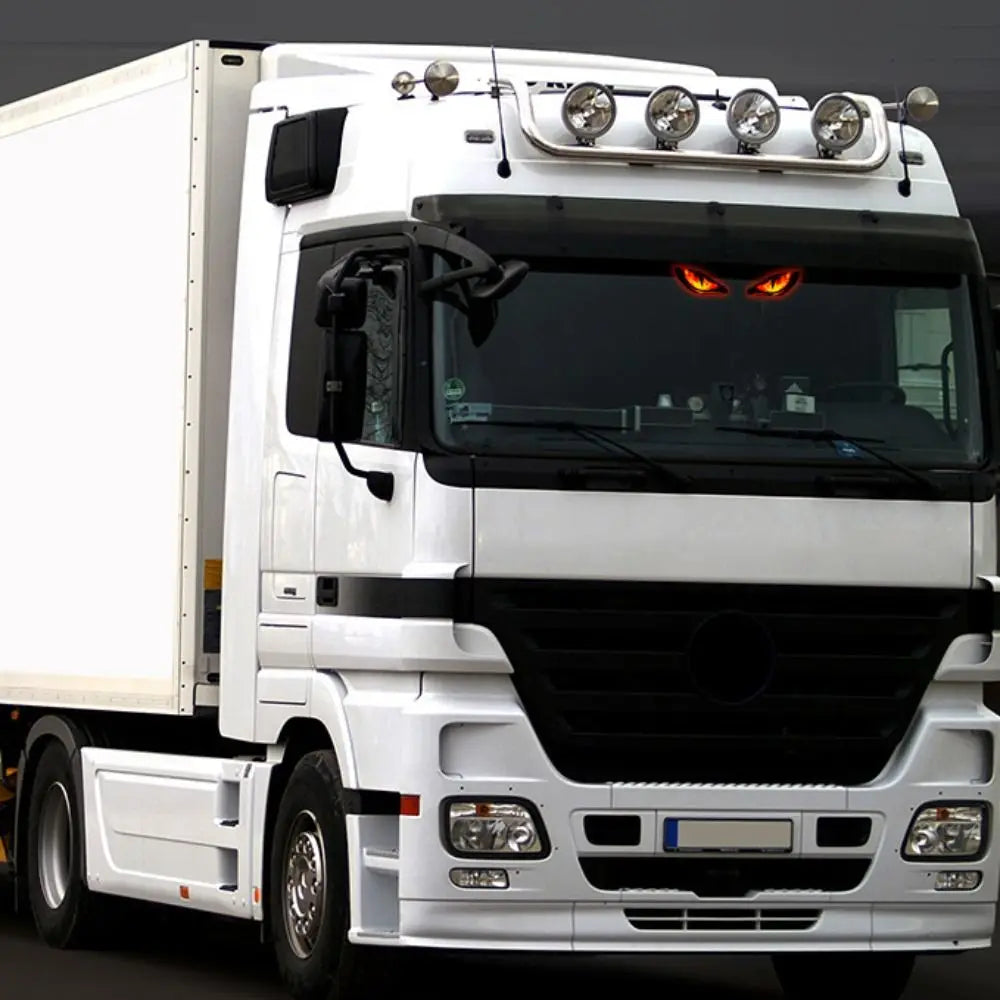 Ein weißer LKW mit blinkenden Solaranwarnleuchten auf der Dach- und Kühlergrillmontage.
