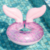 Pink inflatable swim ring with wing-like fins floating in blue water.
