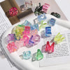 A collection of colorful acrylic alphabet beads in various shades and shapes arranged on a white plate.
