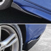 Close-up view of a blue car bumper with an installed black splitter and a silver wheel.