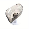 Clear glass soap dish with a leaf design and suction cup mounted on a white base