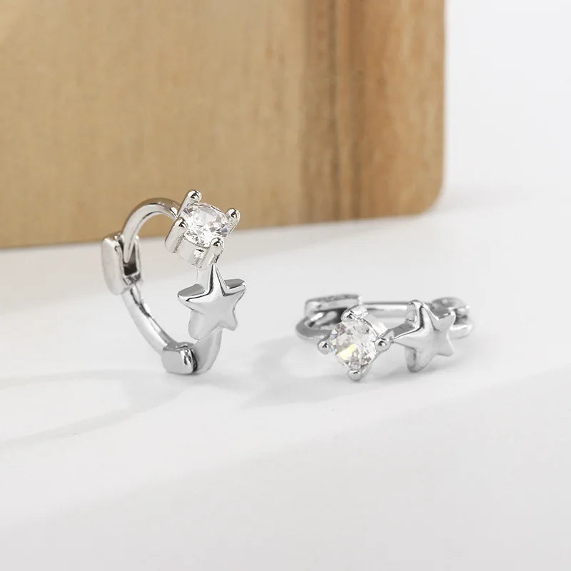 Pendientes de aro plateados con un stud cortado en diamante y diseño de estrella.